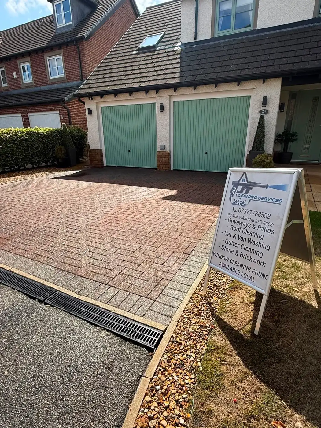 A block-paved driveway in Blackburn after pressure washing, with the JT Cleaning pavement sign in front of the house