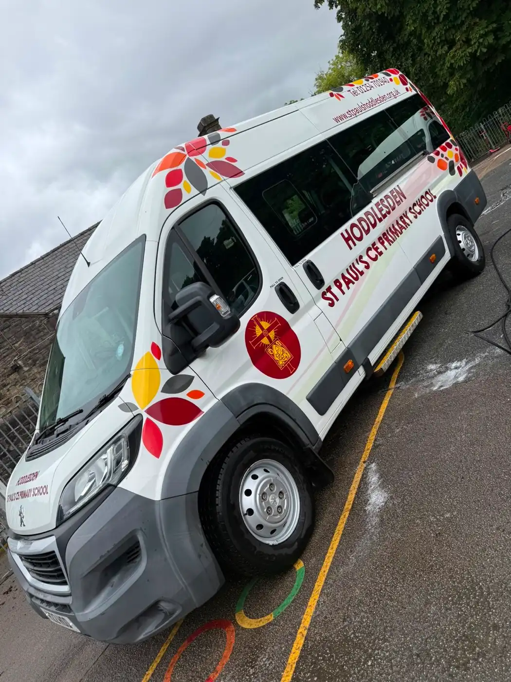 A school minibus part way through a wash on the school grounds